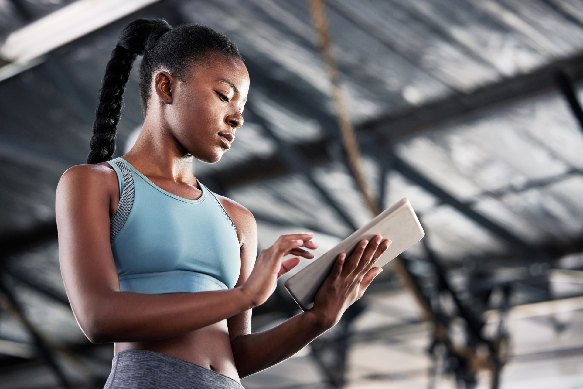 Shot of a sporty young woman using a digital tablet at the gym